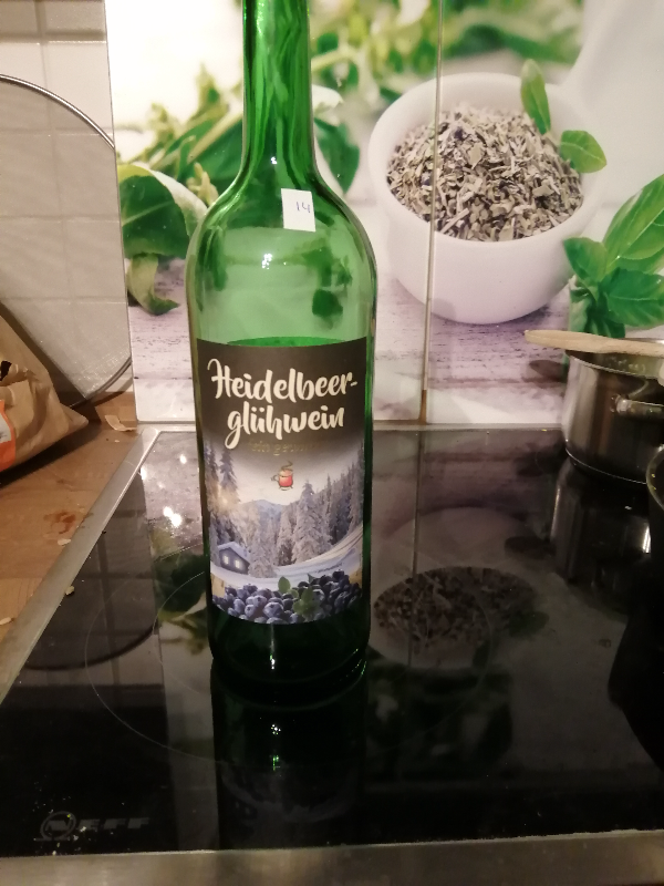 A photograph of a bottle of wine labelled 'Heidelbeerglühwein'